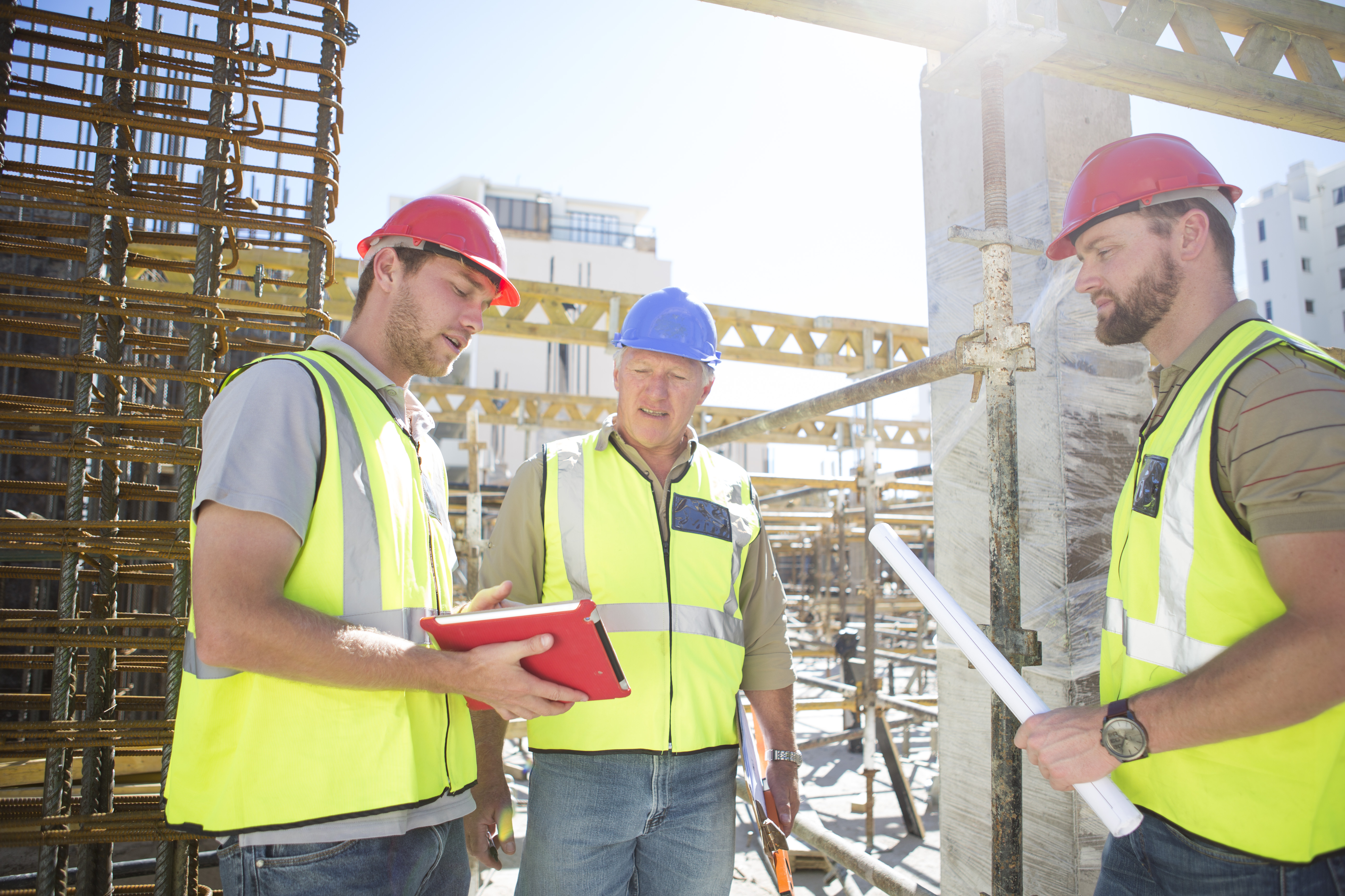 Three construction workers talking in construction site