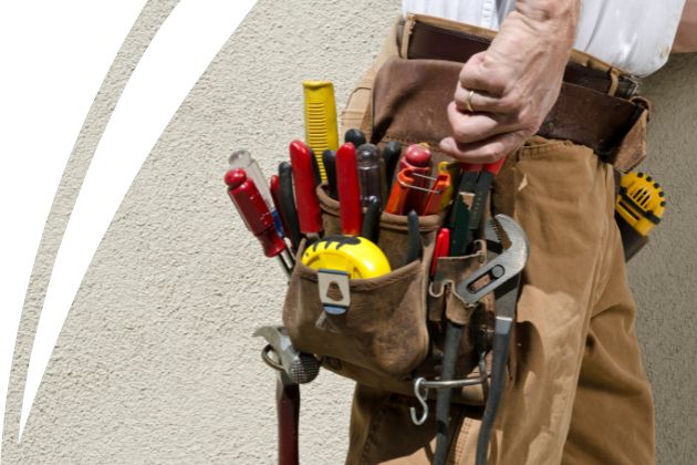 Artesano con un cinturón lleno de herramientas para trabajos de construcción y reparación.