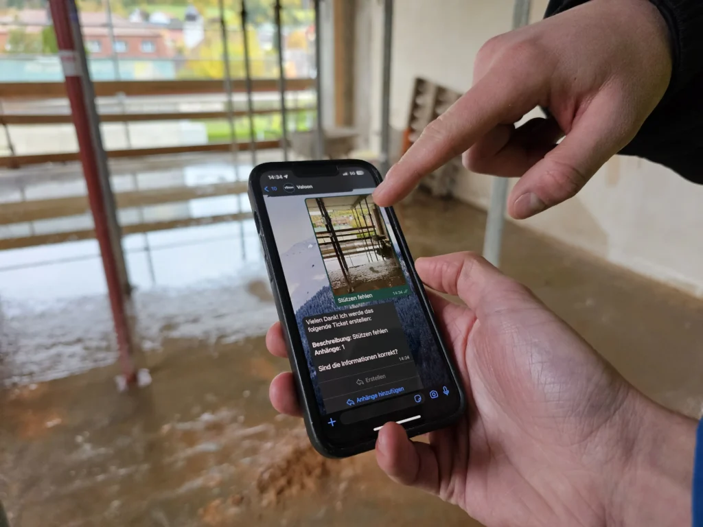 Ein Handy welches die Baustellenkommunikation per WhatsApp darstellt. Dabei wird die App Valoon verwendet um den Austausch effizienter zu gestalten.